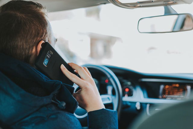 man answering a call in his car