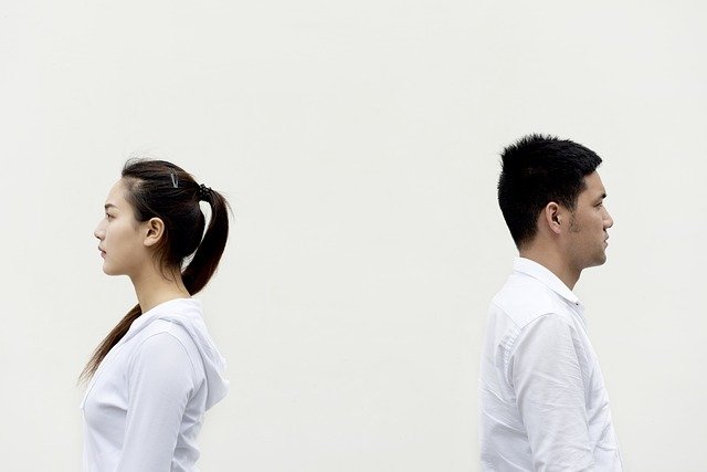 couple standing back to back 