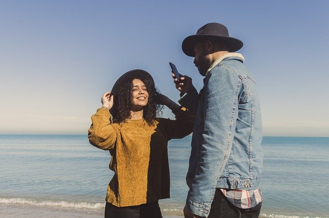man taking photo of a woman using a phone 