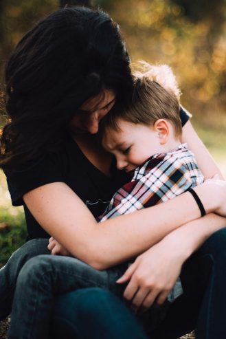mom with her son on her lap crying 