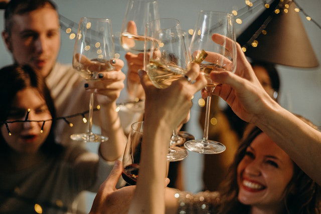 people cheering wine glasses