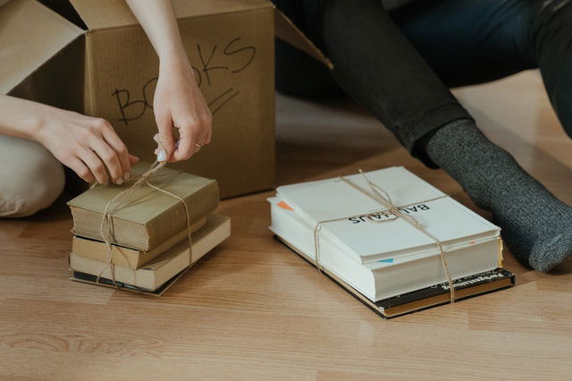 person holding brown cardboard box 