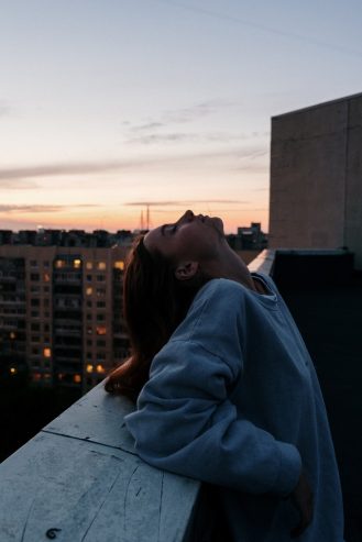 woman in blue hoodie standing at the top of the building 