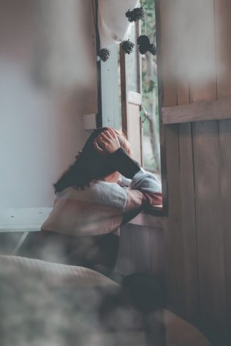 person leaning on wooden window 