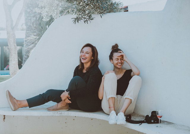 two women sitting on a bench 