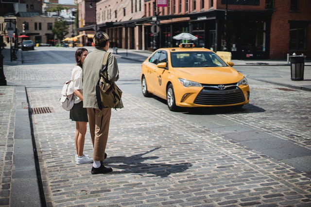 young faceless couple standing on roadside in modern city