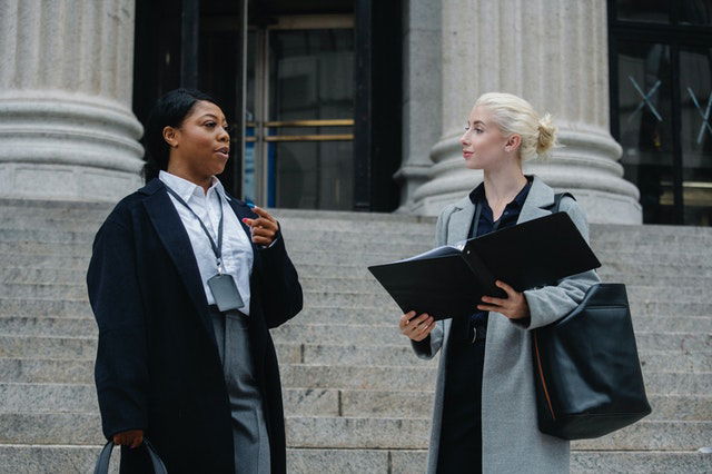 women in corporate attire talking 