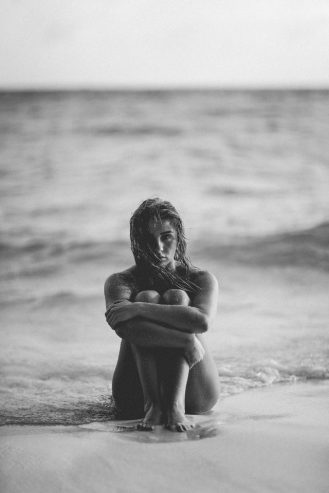 woman sitting in the shore naked