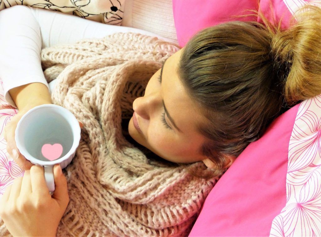 woman laying in bed holding a glass