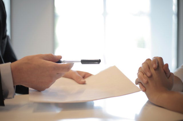 crop man giving contract to woman to sign 