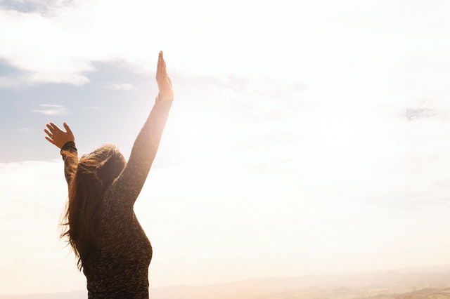photo of a woman raising both hands 