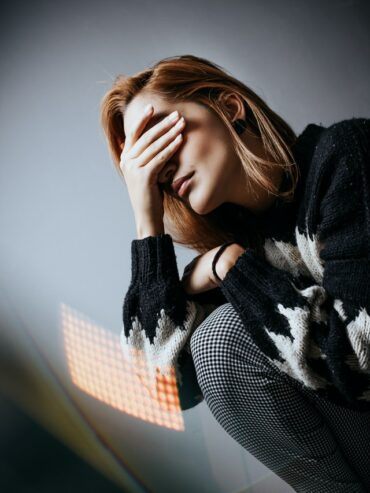 distressed upset woman covering eyes with hand