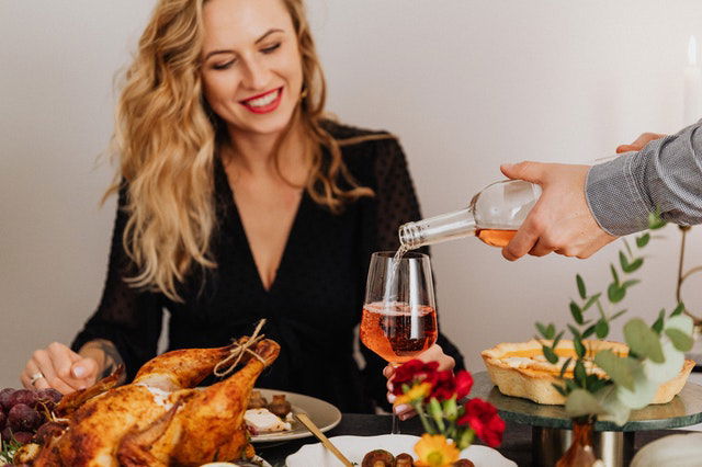 man pouring wine into woman's glass 
