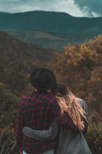 couple standing on top of a hill 