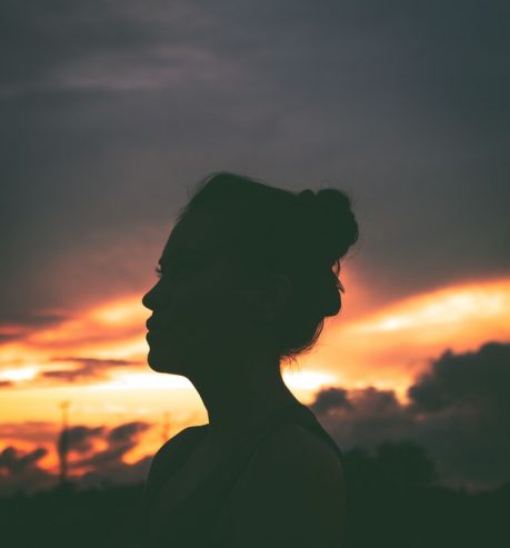  silhouette of woman resting on street during sundown