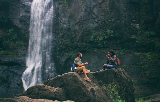 man and woman near a waterfall 