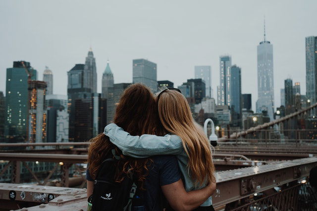 woman in blue shirt and-black backpack standing on top of building