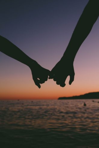 couple holding pinkies 