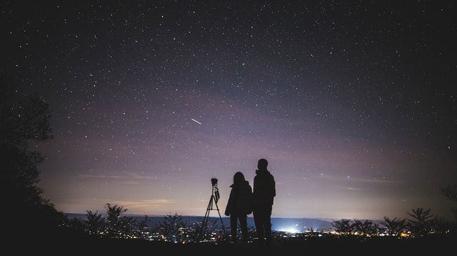  silhouette of two person standing during night time