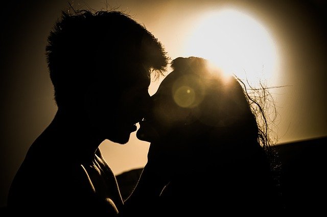 couple kissing while the sun sets 