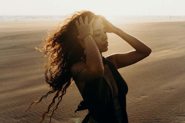 woman in black tank top holding her hair