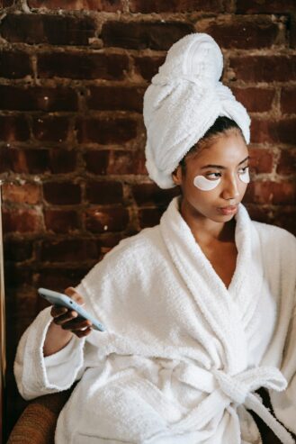 woman with cosmetic patches turning off her phone 
