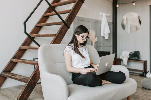 woman using laptop and earphones at home 