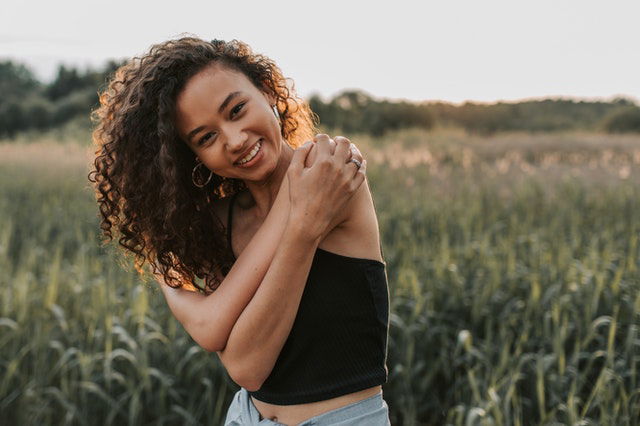 woman wearing black top embracing herself 